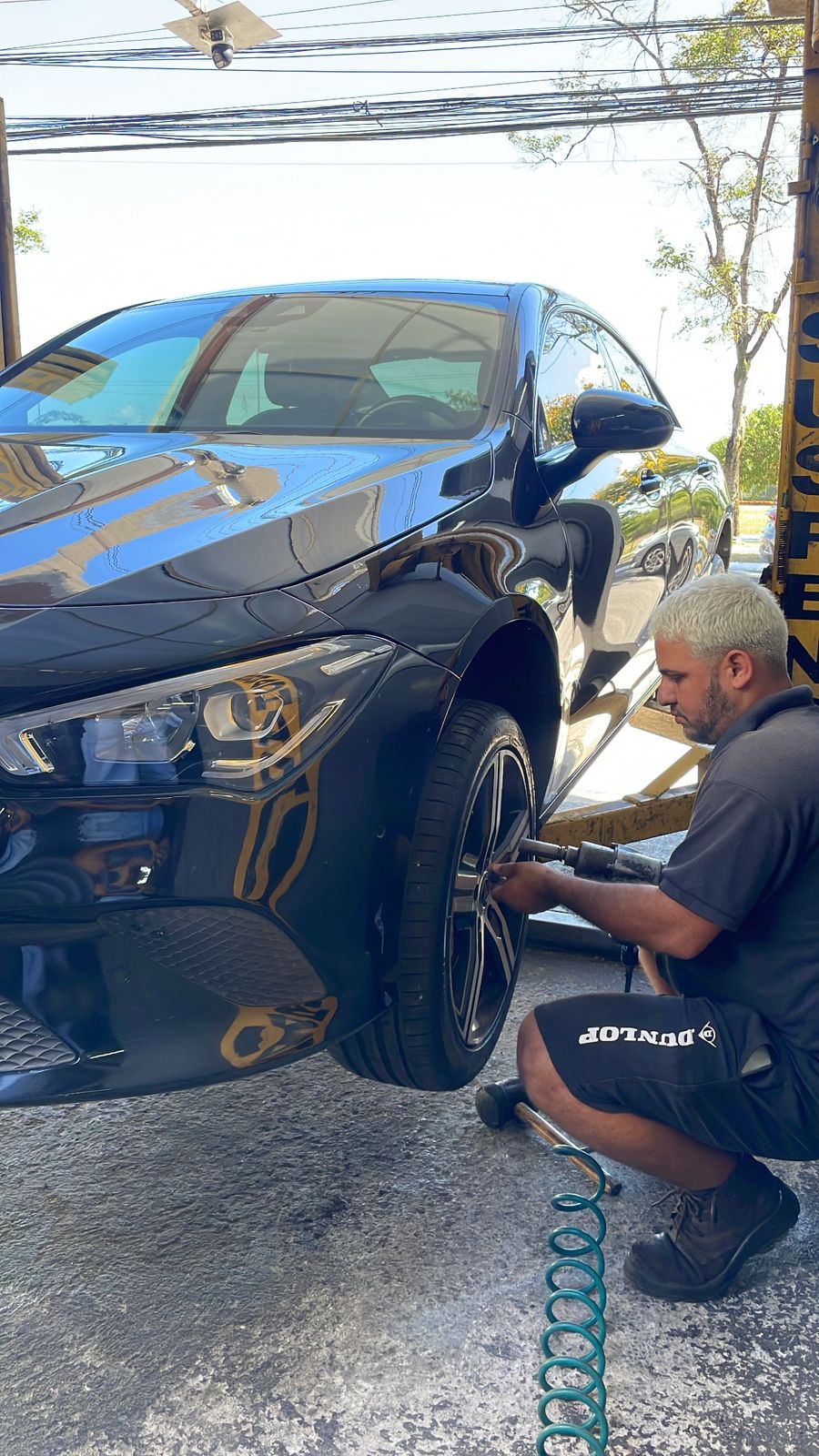 Profissional Dunlop trocando pneu de carro esportivo na WIX PNEUS